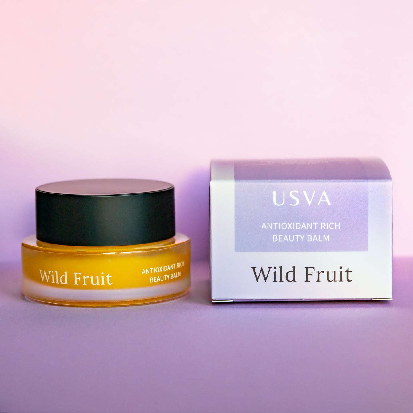 USVA Wild Fruit beauty balm jar and box on a purple background