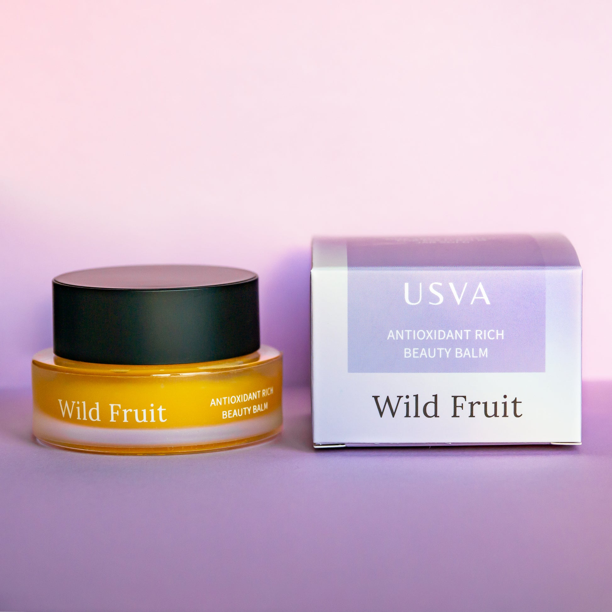 USVA Wild Fruit beauty balm jar and box on a purple background