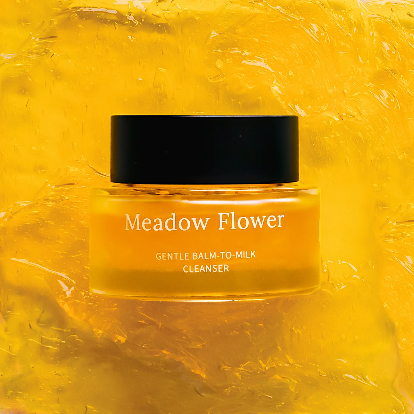 Jar of Meadow Flower Gentle Balm-to-Milk Cleanser on a yellow textured background