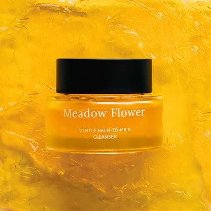 Jar of Meadow Flower Gentle Balm-to-Milk Cleanser on a yellow textured background