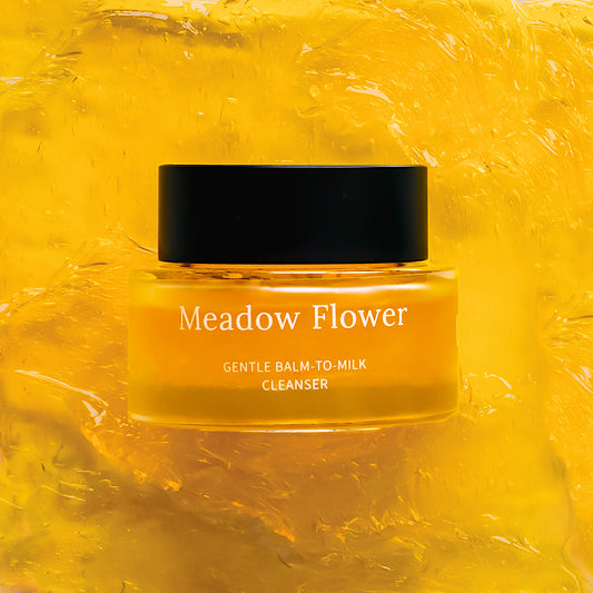 Jar of Meadow Flower Gentle Balm-to-Milk Cleanser on a yellow textured background